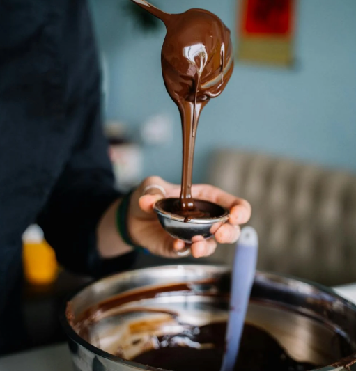 Chocolat coulant d'une cuillière dans un ramequin en métal