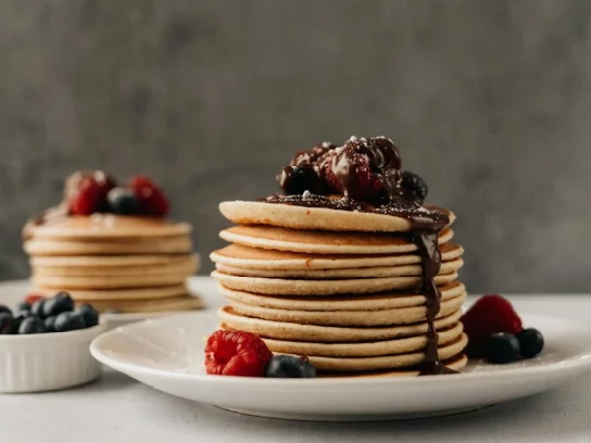 Pancake dans une assiette avec sauce et fruits