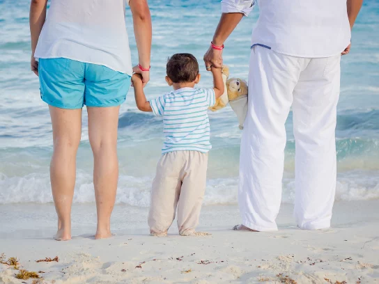 un enfant et ses parents sur une plage